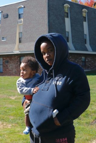 Cheyenne Lewis, 21, holds her 11 mo. old son after she offers he condolences to the family of the victim. (Joshua Murray / Amherst Wire)