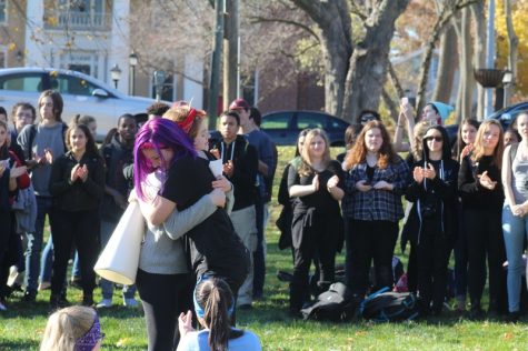 Abigail Morris (right) hugs another ARHS student, surrounded by walkout participants. (Caeli Chesin/Amherst Wire)