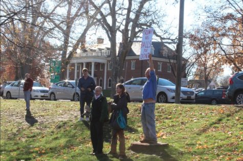 An unnamed man holds signs and yells during speeches at the end of the ARHS walkout on Monday, Nov. 14, 2016. (Elissa Borden/Amherst Wire)