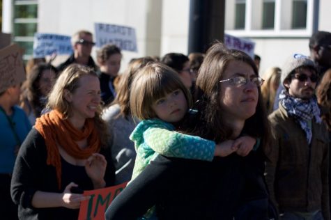 Jennifer Atlee marches with her daughter on her back at the anti-Trump protest in Springfield on Sunday, Nov. 13, 2016. While other protesters felt joy in coming together, Atlee was brought to tears by what a Trump presidency means to her and her daughter. (Morgan Hughes/Amherst Wire)