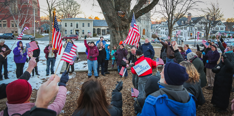 Friends, family and community members who knew citizen journalist Larry Kelley wave their flags in his honor on Monday, Feb. 20, 2017 at the Amherst Town Commons. (Joshua Murray/Amherst Wire)