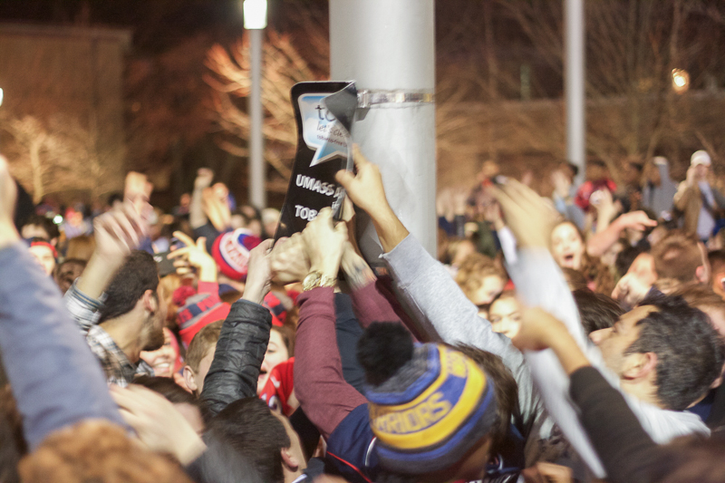 Several students attempted to climb a pole in the center of the Southwest quad and tried ripping a sign off of it. Other students threw beer cans and chunks of ice at some who tried. (Morgan Hughes/Amherst Wire)