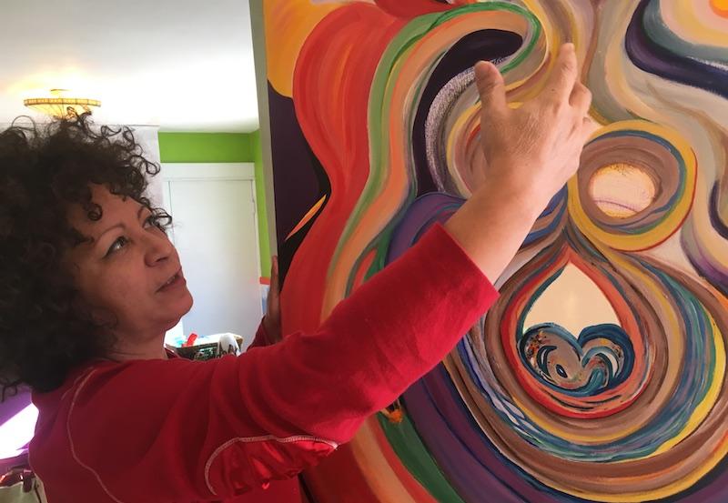 Alvilda Sophia Anaya-Alegría holds up and describes one of her paintings on Feb. 17, 2017. (Jackson Cote/Amherst Wire)