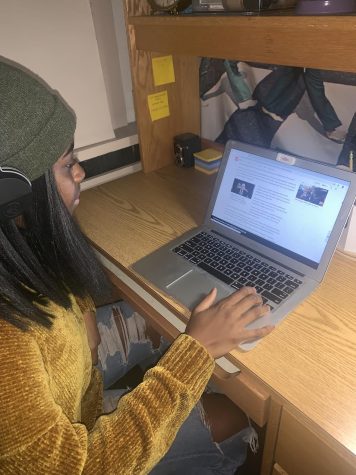 Amaka Agozino freshman political science major scrolls through online news site