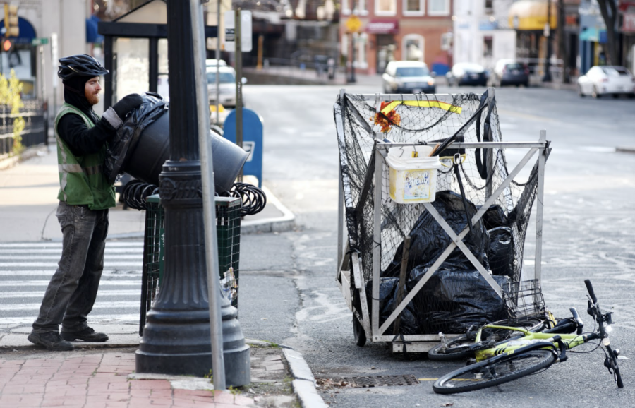 Ethan+Tupelo%2C+a+member+of+the+Pedal+People%2C+empties+a+trash+can+in+downtown+Northampton+in+April+2020.+