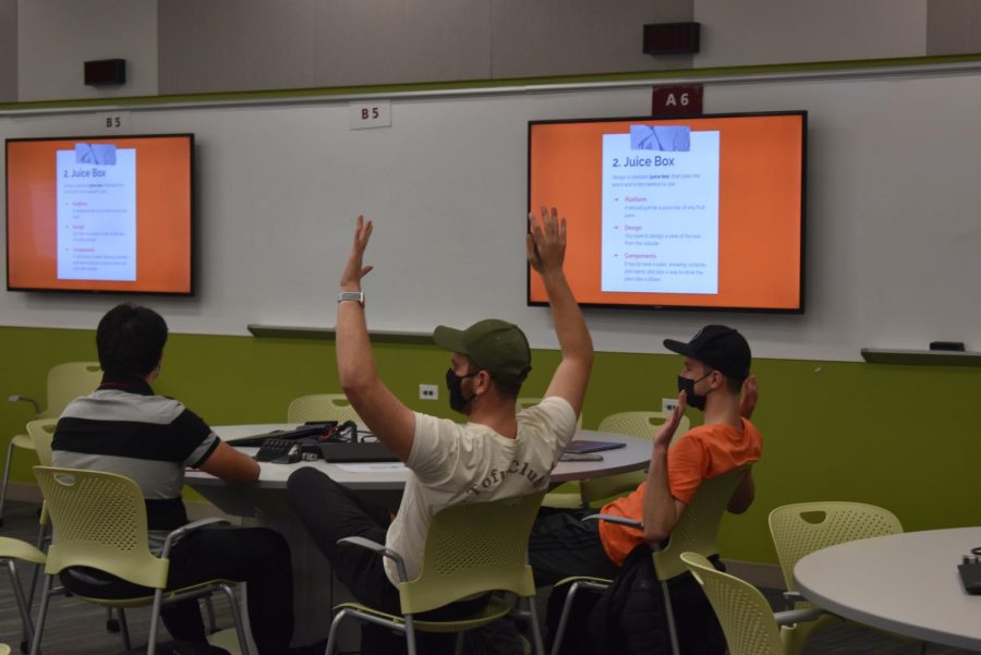Dylan Landman raises his hands to signal his team's completion. Photo by Tristan Smith