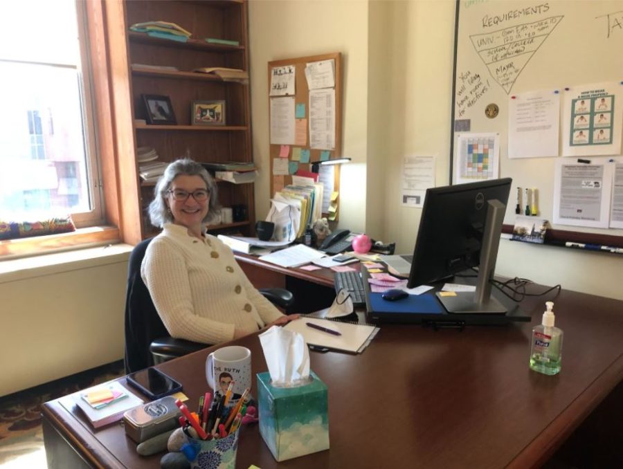 Senior Academic Advisor Amy Grieger of the Political Science department smiles at her desk.