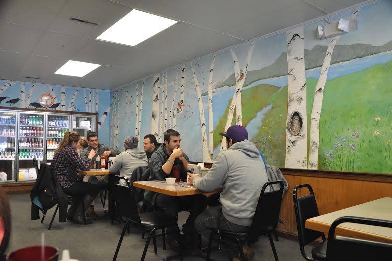 A creative mural covers the entire interior wall of the restaurant